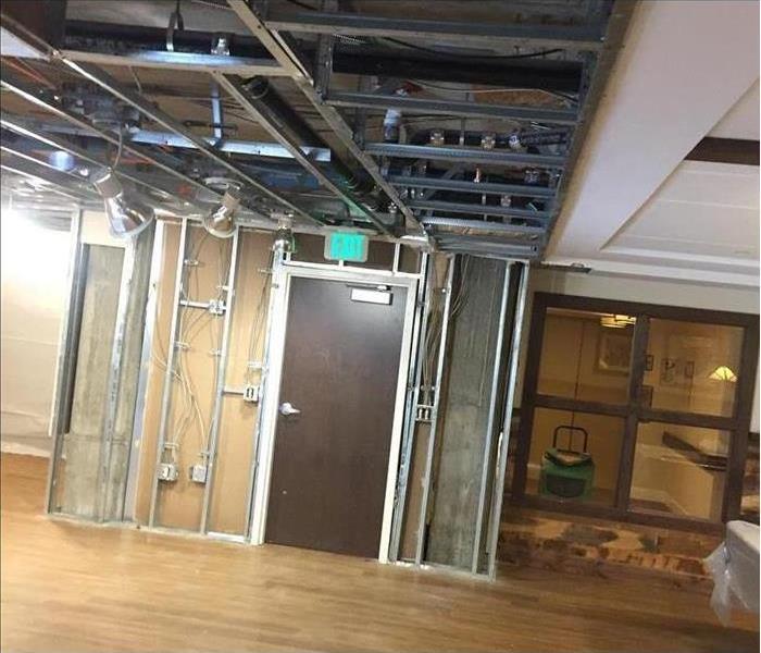 Same commercial space w/ drywall and ceiling panels removed and dry floor
