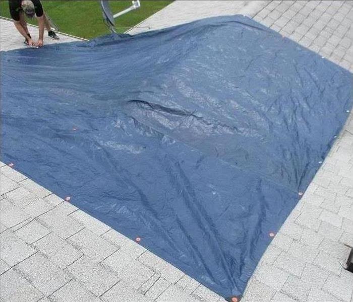 Blue tarp on a storm damaged rooftop