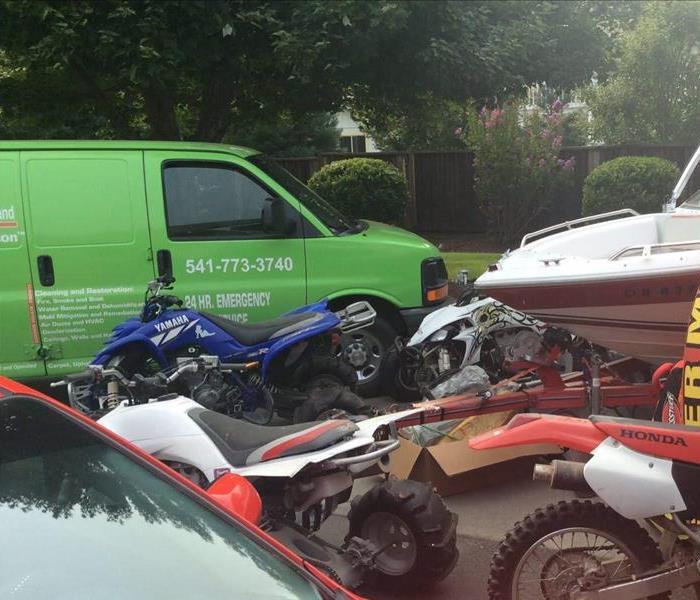 Picture of a van, boat, ATVs, and a motorcycle